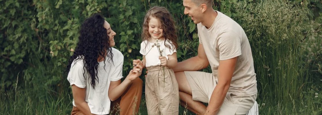 A joyful family enjoying time together in a lush green field.